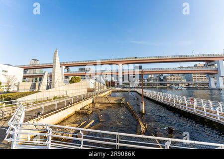 Una parte danneggiata della banchina lasciò come era dopo il terremoto di Kobe come memoriale, sullo sfondo la Hanshin Express Way. Ora d'oro, cielo blu. Foto Stock