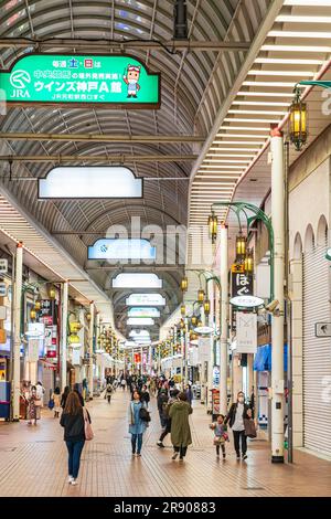 Ammira la trafficata via pedonale dello shopping di Kyusaigokukaido, una galleria di sponde coperte nel quartiere Motomachi di Kobe durante la sera. Foto Stock