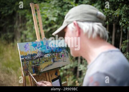 Glastonbury, Regno Unito. 23 giugno 2023. L'artista Peter Brown, che ha partecipato al festival per diversi anni, dipinge una scena fotografata durante il Glastonbury Festival 2023 presso la Worthy Farm. Foto di Julie Edwards Credit: JEP Celebrity Photos/Alamy Live News Foto Stock