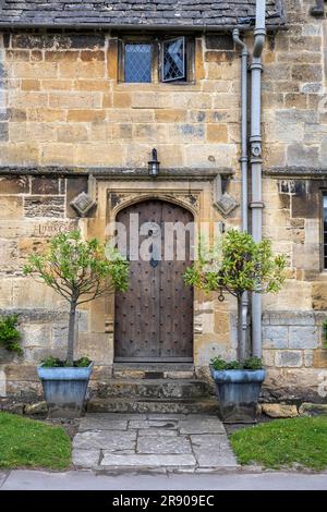 Vecchia casa in pietra nel dettaglio con vecchia porta d'ingresso in legno, Broadway, Cotswolds, Worcestershire, Inghilterra, Regno Unito Foto Stock