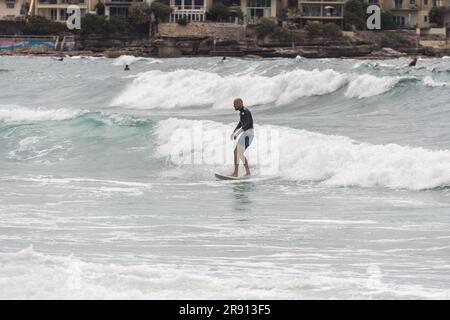 Il surfista cavalca un'onda a Bondi Beach, chiamata anche Bondi Bay, è una famosa spiaggia in Australia, situata vicino a Sydney, Australia, nel novembre 2012 Foto Stock