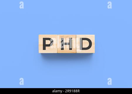 PHD (Dottore di filosofia) cubi di legno su sfondo blu Foto Stock