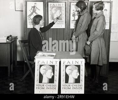 Chicago, Illinois: 20 febbraio 1928 Chicago stabilisce un nuovo programma per una migliore salute tra le giovani donne mangiando i cibi giusti. Due Girl Scout le cui truppe si sono unite alla campagna ammirano il poster "Paint Your Cheeks from Inside" (dipinge le guance dall'interno). Foto Stock