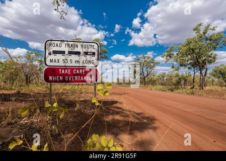 Un cartello nell'Outback vicino a una strada sterrata avverte la gente sui treni stradali nell'Australia Occidentale Foto Stock