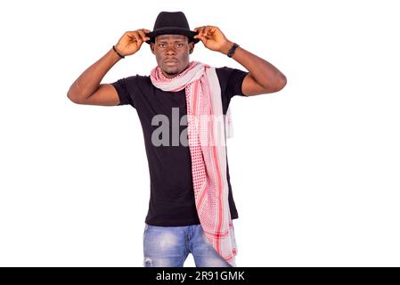 ritratto di un bel giovane sicuro di sé che indossa un cappello e una sciarpa intorno al collo. Foto Stock
