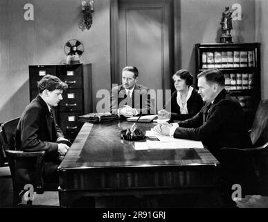 Hollywood, California: c. 1934 attore Wallis Clark, (R) come capo in una scena cinematografica in cui le cose non vanno bene per il giovane impiegato dalla sua scrivania. Foto Stock