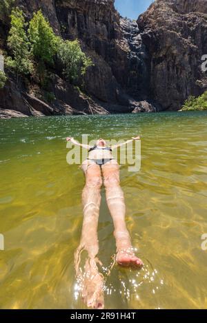 Una donna si gode una nuotata fresca nelle acque fresche di un buco nel Parco Nazionale di Kakadu in Australia Foto Stock