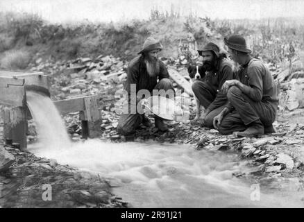 Rockerville, Dakota Territory, 1889 tre minatori d'oro con il loro cane, che cercavano e lavano l'oro in un ruscello. Foto Stock