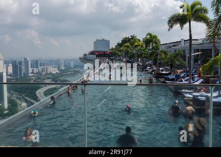 La gente si rilassa nella piscina sul tetto di un hotel di lusso affacciato sulla città di Singapore Foto Stock