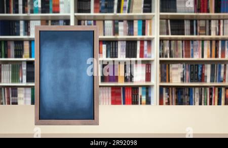 Una lavagna vuota viene visualizzata in modo evidente in una stanza con una libreria sullo sfondo Foto Stock