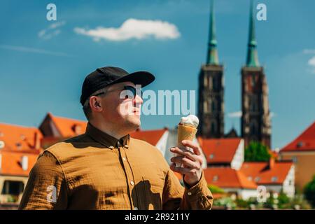 Uomo che indossa occhiali da sole che regge un gelato nelle giornate di sole Foto Stock