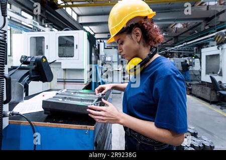 Tecnico addetto alla manutenzione che lavora in fabbrica utilizzando la robotica Foto Stock