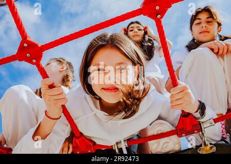 Amici adolescenti che giocano nella palestra della giungla al parco giochi Foto Stock