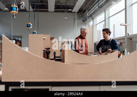 Uomo d'affari che parla di mobili in officina Foto Stock