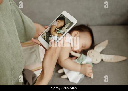 Madre che scatta foto di una figlia che dorme a casa Foto Stock