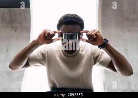 Giovane che regola occhiali cyber Foto Stock