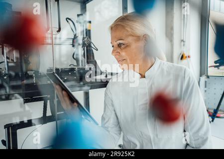 Scienziato sorridente che utilizza un tablet PC in laboratorio Foto Stock