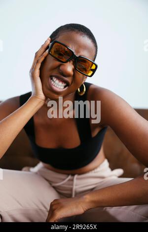 Giovane donna con i capelli corti che stringono i denti Foto Stock