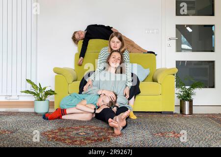 Famiglia rilassante nel salotto di casa Foto Stock