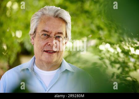 Uomo anziano con i capelli grigi sorridente nel parco Foto Stock