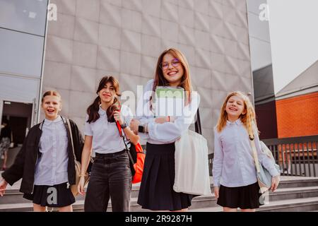 Studentesse che indossano uniformi in piedi davanti all'edificio scolastico Foto Stock