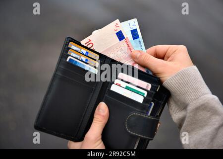 mano che prende banconote dalla borsa Foto Stock
