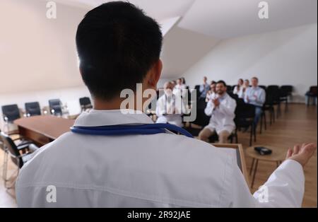 Medico che ha discusso con il pubblico nella sala riunioni durante la conferenza medica, primo piano Foto Stock