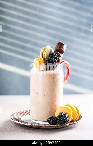 Frullato glassato al cioccolato con ciambelle e dolci. Folle freakshake alimentare tendenza. Spazio di copia Foto Stock