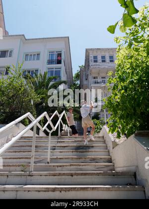 I turisti che fanno foto sui gradini di fronte a una proprietà nella città di Adalar sull'isola di Büyükada, le Isole Principesse, il Mare di Marmara, vicino a Istanbul, Turchia Foto Stock