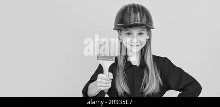 Ristrutturazione bambino, futuro ristrutturatore. Miglioramento. Riparazione superficie. Felice ragazza teen tenere pennello. Allestitore per bambini in un poster orizzontale del casco Foto Stock