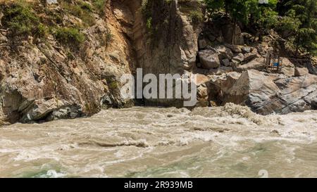 Acqua fresca e limpida che scorre lungo un'acqua fangosa nel fiume Foto Stock