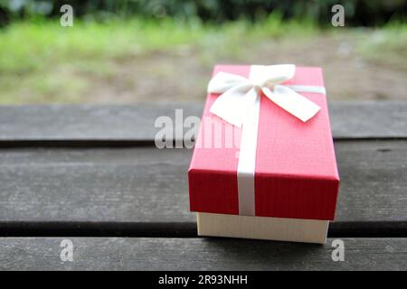 Vari scatti di confezioni regalo con luce solare sul prato del parco in una giornata di sole estiva Foto Stock