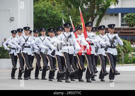 Gli agenti di polizia marciano con le bandiere della Cina e di Hong Kong durante la sfilata. Una parata di polizia che passa fuori si tiene all'Hong Kong Police College. Più di un centinaio di agenti di polizia si sono diplomati al Collegio di polizia questo mese. La sfilata simboleggia che hanno finito di studiare al college di polizia e sono diventati un ufficiale di polizia formale d'ora in poi. Il vice Commissario della polizia (operazioni), Yuen Yuk-kin, è stato il responsabile della revisione alla sfilata di ispettori in prova e reclutano agenti di polizia. Foto Stock