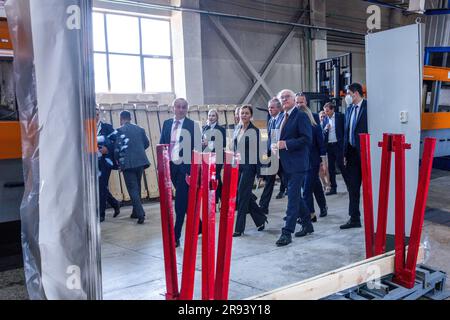 Bischkek, Kirghizistan. 23 giugno 2023. Il presidente tedesco Frank-Walter Steinmeier (al centro) si riflette in un grande specchio durante una visita alla società Interglass. L'azienda Interglass impiega 1.700 persone e produce vetri e specchi. Credito: Jens Büttner/dpa/Alamy Live News Foto Stock