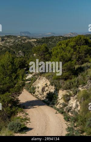 Piccola strada di montagna ghiaiosa che passa sopra una catena montuosa, Costa Blanca, Alicante, Spagna Foto Stock