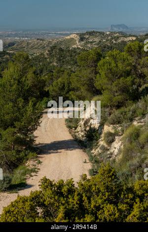 Piccola strada di montagna ghiaiosa che passa sopra una catena montuosa, Costa Blanca, Alicante, Spagna Foto Stock