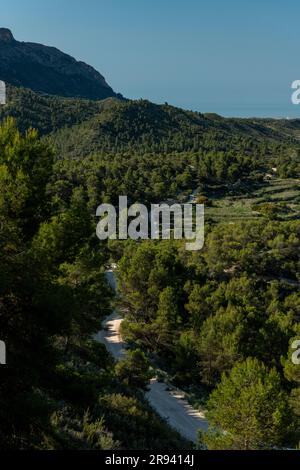 Piccola strada di montagna ghiaiosa che passa sopra una catena montuosa, Costa Blanca, Alicante, Spagna Foto Stock