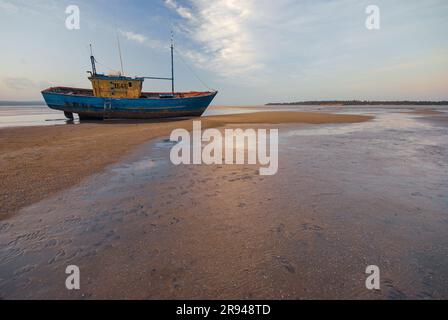 Inhambane, Mozambico - Ottobre 12th 2009: Una foto di una nave in disuso durante la bassa marea, catturata al tramonto. Foto Stock