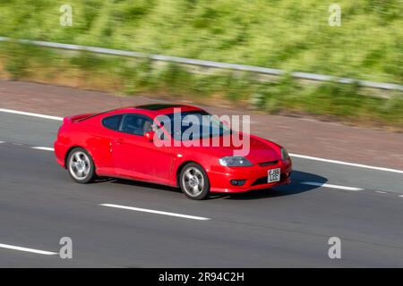 2006 Red Hyundai Coupe se Auto, benzina 1975 cc; viaggia a velocità sostenuta sull'autostrada M6 a Greater Manchester, Regno Unito Foto Stock