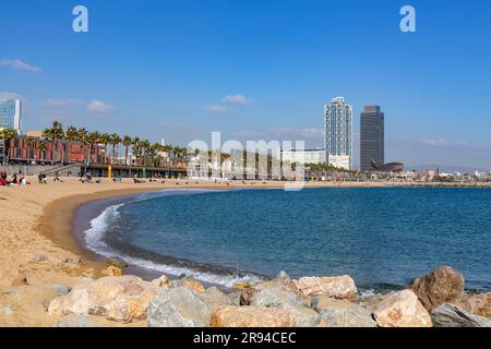 Barcellona, Spagna - FEB 10, 2022: Edifici e persone lungo la spiaggia di Barceloneta nel quartiere Ciutat Vella di Barcellona, la costa mediterranea, Spai Foto Stock