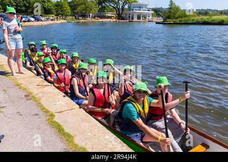 Poole, Dorset, Regno Unito. 24 giugno 2023. In una calda giornata di sole, la folla si ritrova a sostenere la gara di barche Poole Dragon Boat Race sul lago di Poole Park. La squadra di Neils Newts si prepara. Crediti: Carolyn Jenkins/Alamy Live News Foto Stock