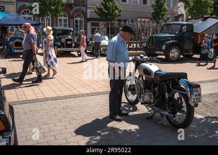 Kaiserslautern, Germania. 24 giugno 2023. Anziano che ispeziona una moto d'epoca a Schillerplatz (Square). Il 15° Kaiserslautern Classics combina una mostra di auto d'epoca con l'ex ADAC Trifels Historic rallye (ora sotto il nuovo nome "ADAC Trifels Oldtimerwanderung") e una riunione in Vespa. L'evento inizia il sabato alle 8:30 e prosegue in varie località pubbliche del centro città per tutto il giorno, accompagnato da band di musica dal vivo. Credito: Gustav Zygmund/Alamy News Foto Stock