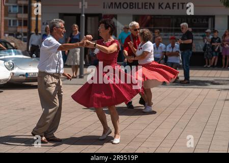 Kaiserslautern, Germania. 24 giugno 2023. Coppie danzanti durante lo spettacolo di auto d'epoca con musica dal vivo a Schillerplatz (Piazza). Il 15° Kaiserslautern Classics combina una mostra di auto d'epoca con l'ex ADAC Trifels Historic rallye (ora sotto il nuovo nome "ADAC Trifels Oldtimerwanderung") e una riunione in Vespa. L'evento inizia il sabato alle 8:30 e prosegue in varie località pubbliche del centro città per tutto il giorno, accompagnato da band di musica dal vivo. Credito: Gustav Zygmund/Alamy News Foto Stock