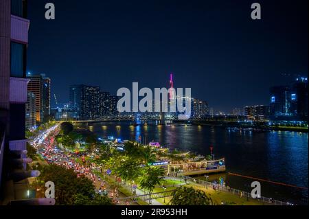 Vista notturna del fiume Saigon, del ponte Ba Son e dell'edificio Vinpearl Landmark 81 parzialmente coperto dalla torre del ponte nella città di ho chi Minh, Vietnam. Foto Stock