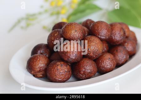 Unniyappam. Frittelle di riso dolci fatte con una pastella di riso, banana, jaggery, pezzi di cocco fritti con ghee, semi di sesamo nero e aromatizzate con cardamomo. Foto Stock