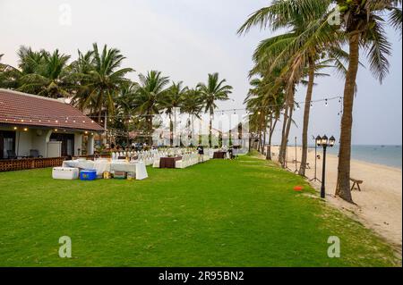 Vista mare e giardini con tavoli preparati per una grande festa di compleanno al Palm Garden Resort hotel, Hoi An, Vietnam. Foto Stock