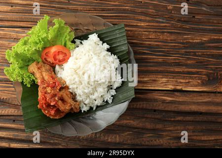 Ayam Geprek Sambal BAwang con riso bianco al vapore. Cibo di strada popolare indonesiano, spazio di copia per testo, ricetta o pubblicità Foto Stock