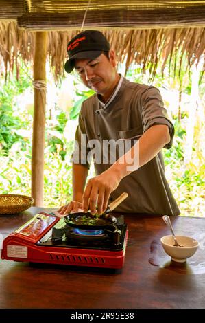 Chef e tutor dimostrano come cucinare autentici pancake vietnamiti Hoi An presso la scuola di cucina Red Bridge alla periferia di Hoi An, in Vietnam. Foto Stock