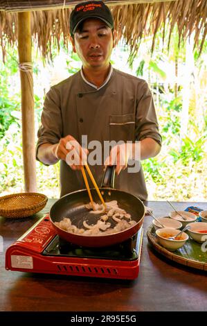 Chef e tutor dimostrano come cucinare autentici frutti di mare vietnamiti presso la scuola di cucina Red Bridge alla periferia di Hoi An, Vietnam. Foto Stock