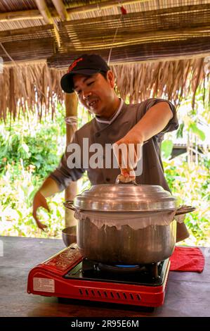 Chef e tutor dimostrano come cucinare la carta di riso utilizzata per panini e spaghetti presso la scuola di cucina Red Bridge alla periferia di Hoi An, in Vietnam. Foto Stock